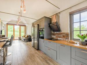 a kitchen with white cabinets and a tv on the counter at The Cottage High Wykehurst End in Cranleigh