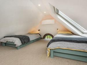 a attic bedroom with two beds and a staircase at The Cottage High Wykehurst End in Cranleigh