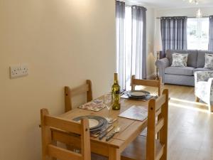 Saint Hilary的住宿－Lindum Leys，一间带木桌和椅子的用餐室