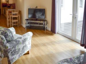 a living room with a flat screen tv and a couch at Lindum Leys in Saint Hilary