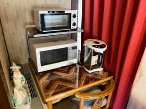 a microwave and a toaster oven on a table at ペンションcollege白馬 in Hakuba