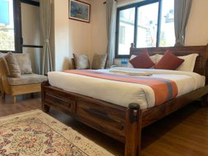 a bedroom with a large bed and a chair at Hotel Ramanam in Kathmandu