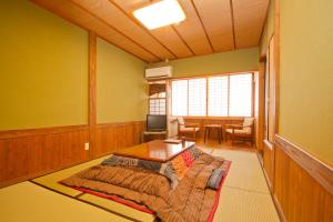 Cette chambre comprend un lit et une table. dans l'établissement Shinwaen, à Aso