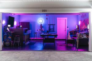 巴拿馬市海灘的住宿－Emerald-Gem-Inn • Laguna Haven/Beach Home!，一间拥有紫色墙壁和桌椅的房间