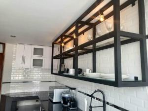 una cucina con bancone e piatti su una mensola di Aurora Guest House - Luxury Apartment a Huaraz Altre 8 foto