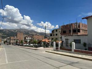 eine leere Straße in einer Stadt mit Bergen im Hintergrund in der Unterkunft Aurora Guest House - Luxury Apartment in Huaraz