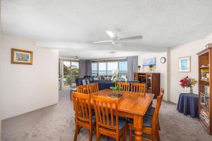 a dining room and living room with a table and chairs at Birdseye View Apartment at Nelson Bay in Nelson Bay