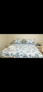 Bett mit blauer und weißer Bettwäsche und Kissen in der Unterkunft Heart Of Aberdeen City Centre 3 Bedrooms Apartment in Aberdeen