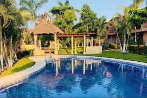 a swimming pool in a yard with a gazebo at Casa a 7 min de playa in Ixtapa