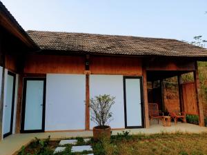 6Nature Bavi Retreat في هانوي: منزل به نوافذ زجاجية كبيرة وفناء