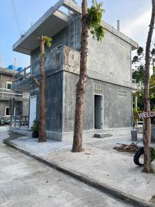 a building with three palm trees in front of it at Koh Tao Little House in Koh Tao