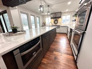 a kitchen with stainless steel appliances and wooden floors at Cheerful 4 bedroom home w/ fireplace & game room in Mason