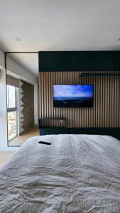 a bedroom with a large bed and a flat screen tv at Depa acogedor en el corazón de la ciudad in Lima