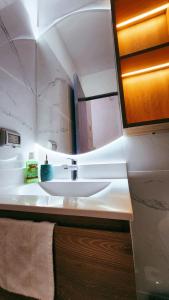 a bathroom with a white sink and a mirror at Depa acogedor en el corazón de la ciudad in Lima