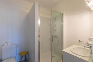 ein weißes Bad mit einer Dusche und einem Waschbecken in der Unterkunft Cabana & Le Gîte de Domange - Proche Mâcon in Igé