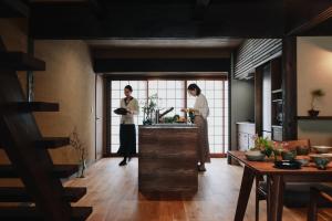 two people standing in a kitchen preparing food at 八百熊川 Yao-Kumagawa in Kumagawa