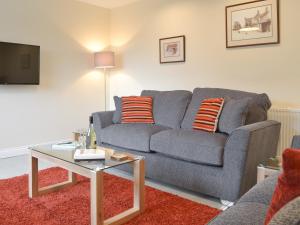 a living room with a gray couch and a table at Mendip in Cheddar