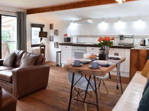 a kitchen and living room with a table and a couch at The Wood House in Buckfastleigh