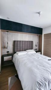 a bedroom with a large white bed with two pillows at Depa acogedor en el corazón de la ciudad in Lima