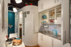 a kitchen with white cabinets and a sink at RomEnjoy Colosseo in Rome