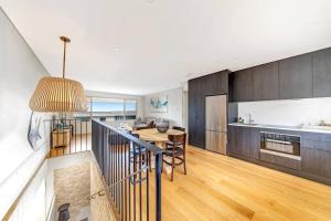 a kitchen and living room with a table and a dining room at Sea and Salt Hyams Beach in Hyams Beach