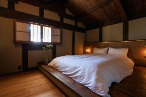 a bedroom with a large white bed with a window at 八百熊川 Yao-Kumagawa in Kumagawa