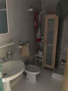 een badkamer met een witte wastafel en een toilet bij Holiday home in Isola Albarella 43176 in Isola Albarella