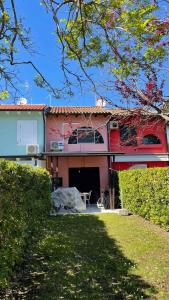 een huis met een oprit en een tuin met een hek bij Holiday home in Isola Albarella 43176 in Isola Albarella