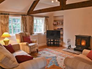 a living room with couches and a wood stove at The Old Stables in Cley next the Sea