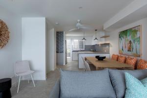 a living room and kitchen with a couch and a table at Beachfront Villa in Coolum Beach