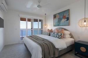 Un dormitorio con una cama grande y una ventana en Beachfront Villa, en Coolum Beach