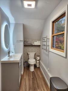 baño con aseo y lavabo y ventana en Le Elona, a private island getaway experience, en Peabody