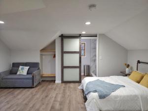 1 dormitorio con cama y sofá en Le Elona, a private island getaway experience, en Peabody