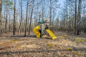 un parque infantil en el bosque con un tobogán amarillo en Bent Tree Cabin, on Private 12.5 Acres + Hot Tub, en Broken Bow