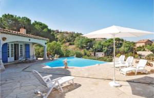 a group of chairs and an umbrella next to a pool at Nice Home In Sainte Maxime With Wifi in Sainte-Maxime