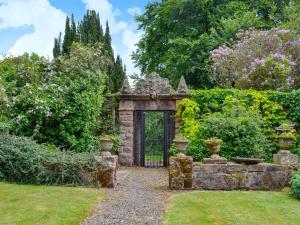 an entrance to a garden with a stone gate at Gilminscroft Gatehouse in Sorn