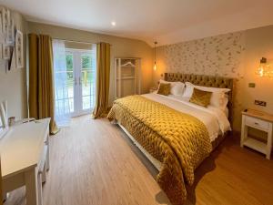 a bedroom with a large bed with a yellow blanket at Bee Cottage-UK39918 in Bride