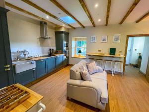 a living room with a couch and a kitchen at Bee Cottage-UK39918 in Bride