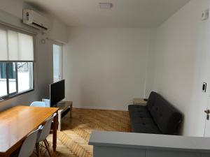 sala de estar con mesa y sofá negro en Súper Precio hasta 3 Pax frente al Polo en Buenos Aires