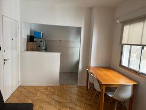 a kitchen with a wooden table and a refrigerator at Súper Precio hasta 3 Pax frente al Polo in Buenos Aires +6 photos