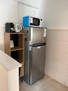 a kitchen with a refrigerator with a microwave on top of it at Súper Precio hasta 3 Pax frente al Polo in Buenos Aires