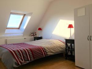 a bedroom with a bed with a red blanket and a window at Maison Trébeurden, 3 pièces, 6 personnes - FR-1-368-4 in Trébeurden