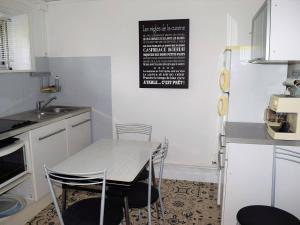 a kitchen with a table and chairs and a refrigerator at Appartement Trégastel, 2 pièces, 4 personnes - FR-1-368-77 in Trégastel