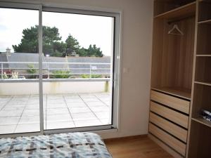 Schlafzimmer mit einer großen Glastür zu einem Balkon in der Unterkunft Maison Pleumeur-Bodou, 6 pièces, 10 personnes - FR-1-368-129 in Pleumeur-Bodou