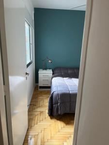1 dormitorio con cama y pared azul en Súper Precio hasta 3 Pax frente al Polo en Buenos Aires
