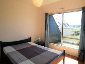 1 dormitorio con cama y ventana grande en Appartement Quiberon, 2 pièces, 5 personnes - FR-1-478-125, en Quiberon