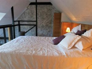 um quarto com uma cama com lençóis brancos e almofadas em Maison Trégastel, 1 pièce, 2 personnes - FR-1-368-211 em Trégastel
