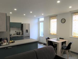 eine Küche mit einem Sofa, einem Tisch und einer Theke in der Unterkunft Appartement rénové 3* avec WIFI, centre-ville Perros-Guirec, proche plages et commerces - FR-1-368-263 in Perros-Guirec