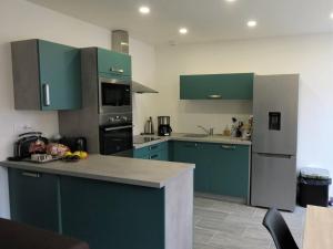 eine Küche mit grünen Schränken und einer Arbeitsplatte in der Unterkunft Appartement rénové 3* avec WIFI, centre-ville Perros-Guirec, proche plages et commerces - FR-1-368-263 in Perros-Guirec