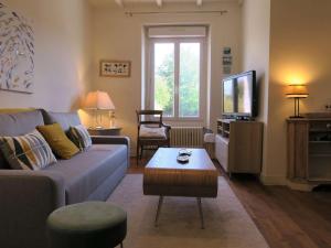 ein Wohnzimmer mit Sofa und Fernseher in der Unterkunft Maison de charme avec jardin, terrasse et WIFI, à 600m de la mer à Pleumeur-Bodou - FR-1-368-294 in Pleumeur-Bodou